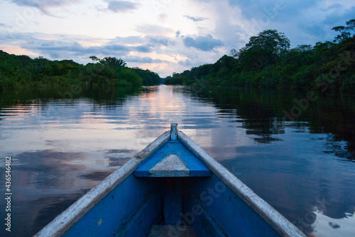 Wooden boat overlooking the sunset or sunrise in the Amazon river © EVA CARRE