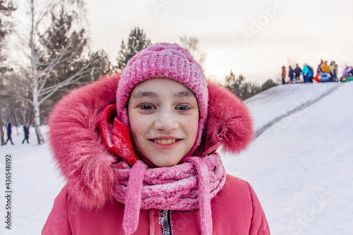 Girl with frost on the eyelashes on the background of a snow hill in the coldest in the world northern residential village Oymyakon.