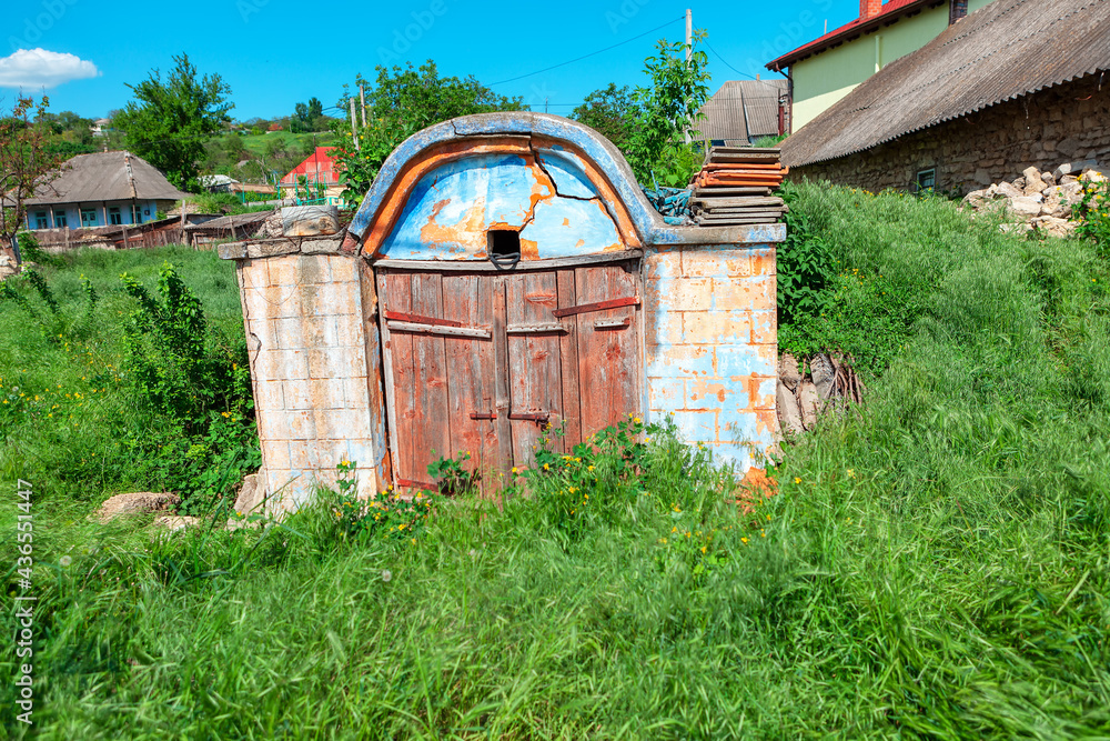 Ancient Cellar for storing wine , exterior view . Old rural cellar with wooden door Ancient Cellar for storing wine , exterior view . Old rural cellar with wooden door