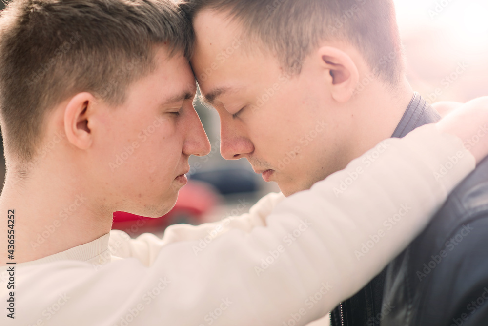 Cute gay couple in the city, tender gentle kissing, smiling Cute gay couple in the city, tender gentle kissing, smiling