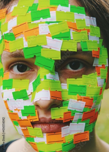 Closeup portrait of woman's face covered with empty price tag labels, abstract art image on stereotype gender roles, social norms, womens rights photo