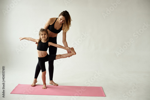 mother and daughter doing yoga together