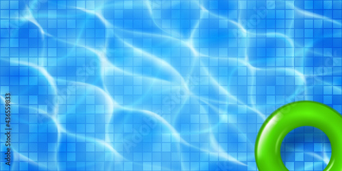 Swimming pool top view with mosaic tiles and inflatable ring. Water surface in light blue colors with sunlight glares and caustic ripples. Summer holiday background.