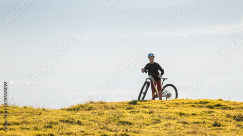 Girl child riding mountain bike at sunset. Beautiful golden summer light.