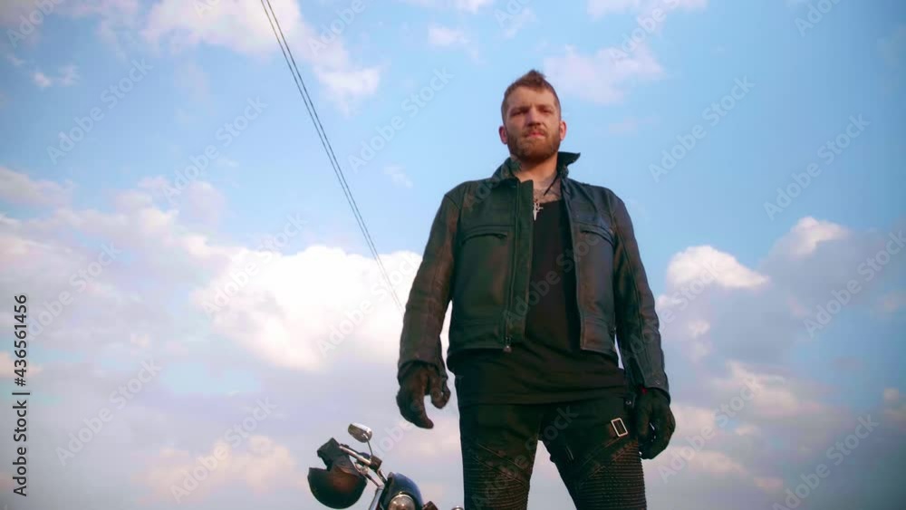 Motorcyclist walks on the road to his motorcycle chopper Motorcyclist walks on the road to his motorcycle chopper