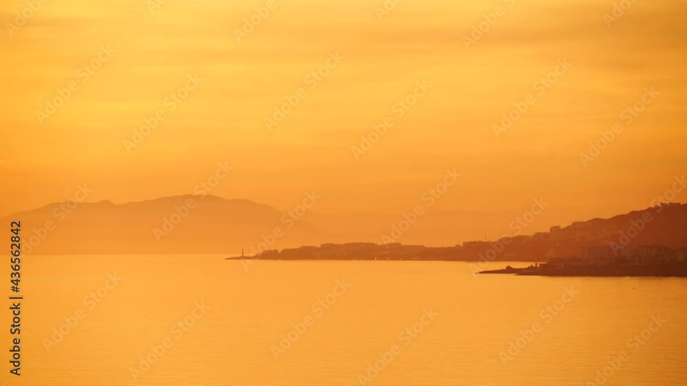 Seascape. Orange sunset over sea coast. View from cliffs of Maro Cerro Gordo Natural Park, Malaga province, Costa Del Sol, Andalusia, Spain. Time lapse Seascape. Orange sunset over sea coast. View from cliffs of Maro Cerro Gordo Natural Park, Malaga province, Costa Del Sol, Andalusia, Spain. Time lapse