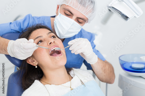 Medical checkup oral cavity of female patient with dental instruments - mirror and probe