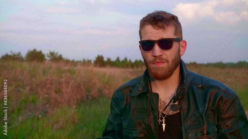 Portrait of a biker on a motorcycle chopper with sun glasses Portrait of a biker on a motorcycle chopper with sun glasses