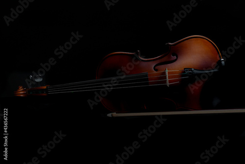 Abstract image of a Violin and violin bow in low-key light photography in a black background, baroque or renaissance style.