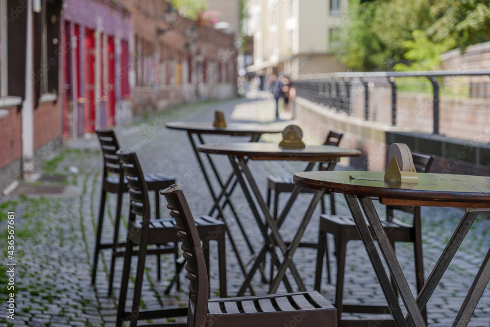 Selective focus at outdoor table and chair without people in front of cafe, bar, and restaurant in walking street old town Düsseldorf, Germany.