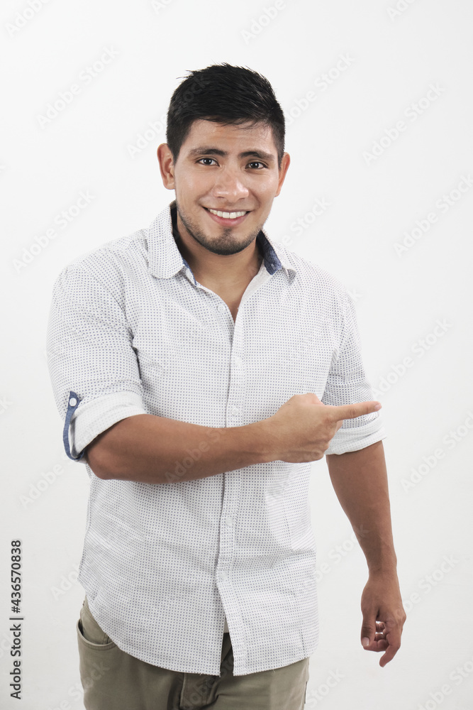 Hombre latino alegre mira a cámara mientras señala tu producto Hombre latino alegre mira a cámara mientras señala tu producto