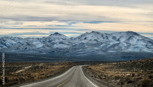 Highway road through yellow desert to snowy mountains. Salt Lake City. Utah. USA 