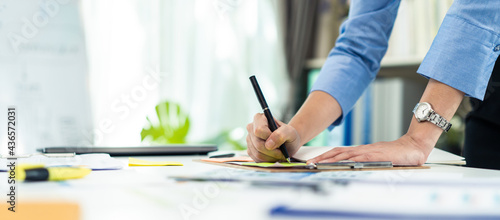 Hand of Businesswoman work in office write paperwork on table with pen