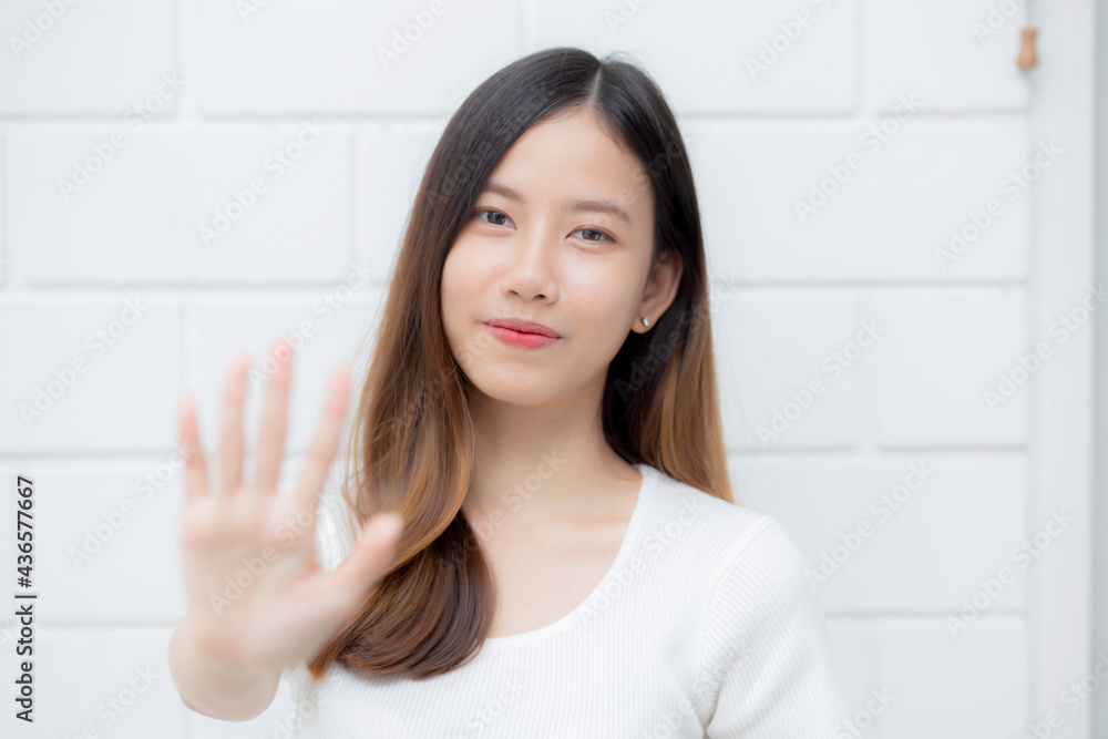 Beautiful young asian woman confident gesture say hello or greeting with waving her hand on cement background at home, friendly welcome, portrait girl cheerful expression happy and satisfied. Beautiful young asian woman confident gesture say hello or greeting with waving her hand on cement background at home, friendly welcome, portrait girl cheerful expression happy and satisfied.