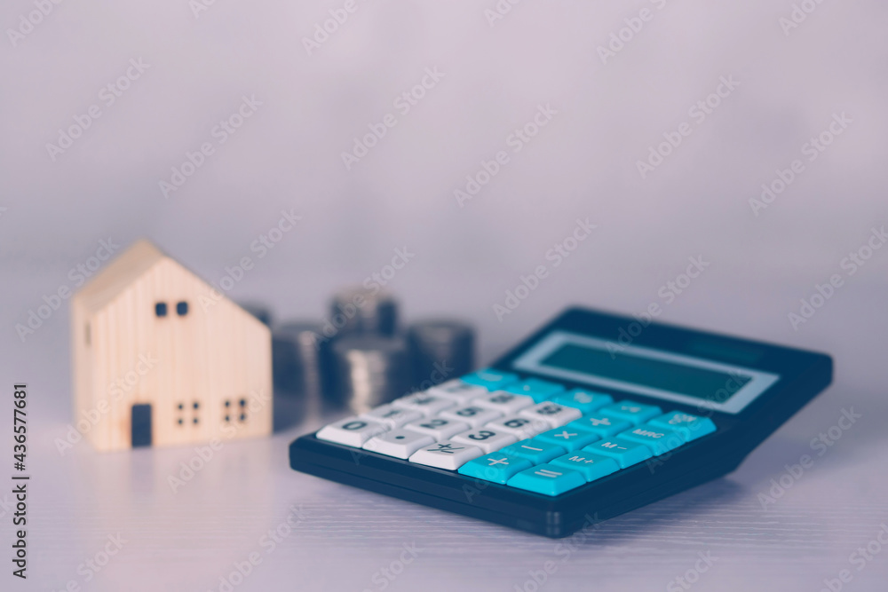 Investment about home with calculator and model house and coins on desk, property and real estate and mortgage, loan and finance, financial saving and account for residential, business concept. Investment about home with calculator and model house and coins on desk, property and real estate and mortgage, loan and finance, financial saving and account for residential, business concept.