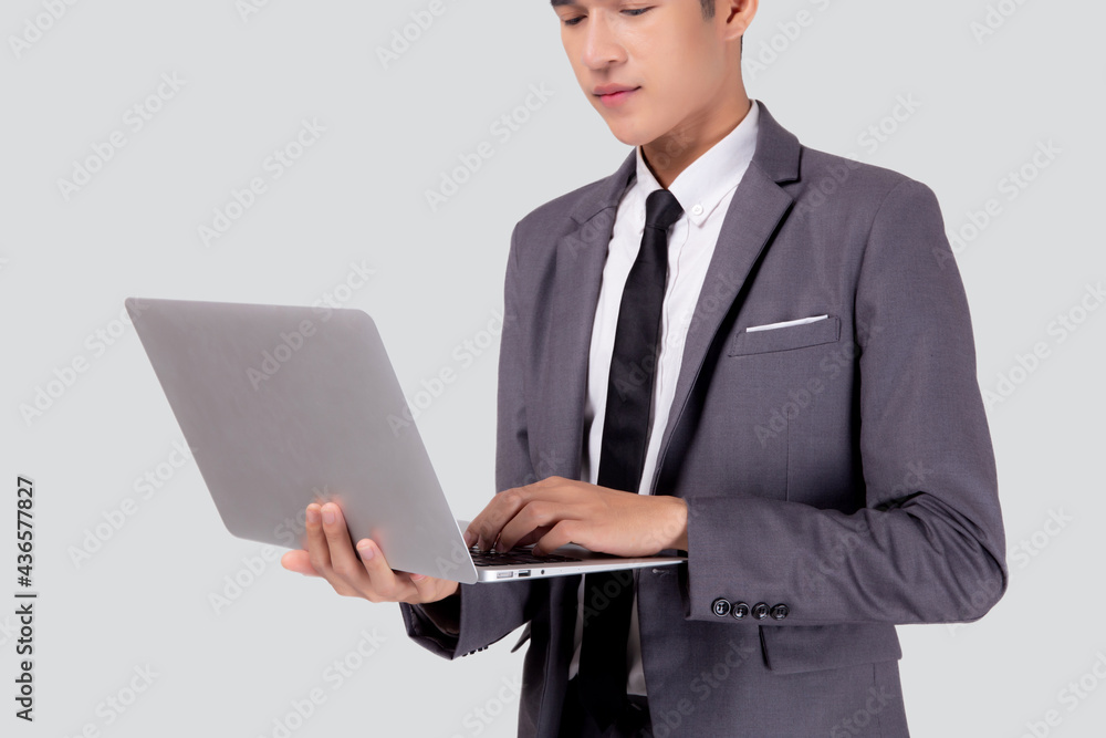 Young asian business man standing work on laptop computer to internet online isolated on white background, businessman confident and notebook, freelance with success, marketing and communication. Young asian business man standing work on laptop computer to internet online isolated on white background, businessman confident and notebook, freelance with success, marketing and communication.