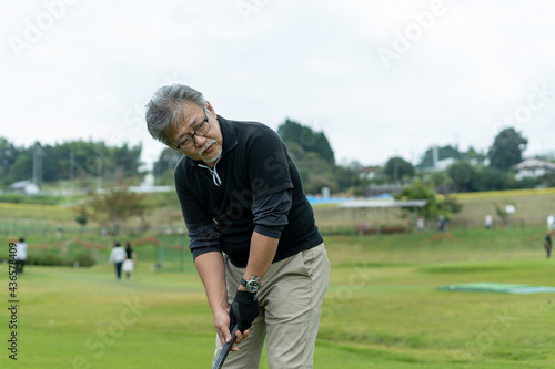 ゴルフを楽しむシニア男性