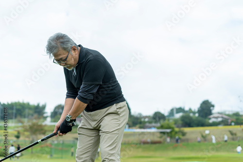 ゴルフを楽しむシニア男性