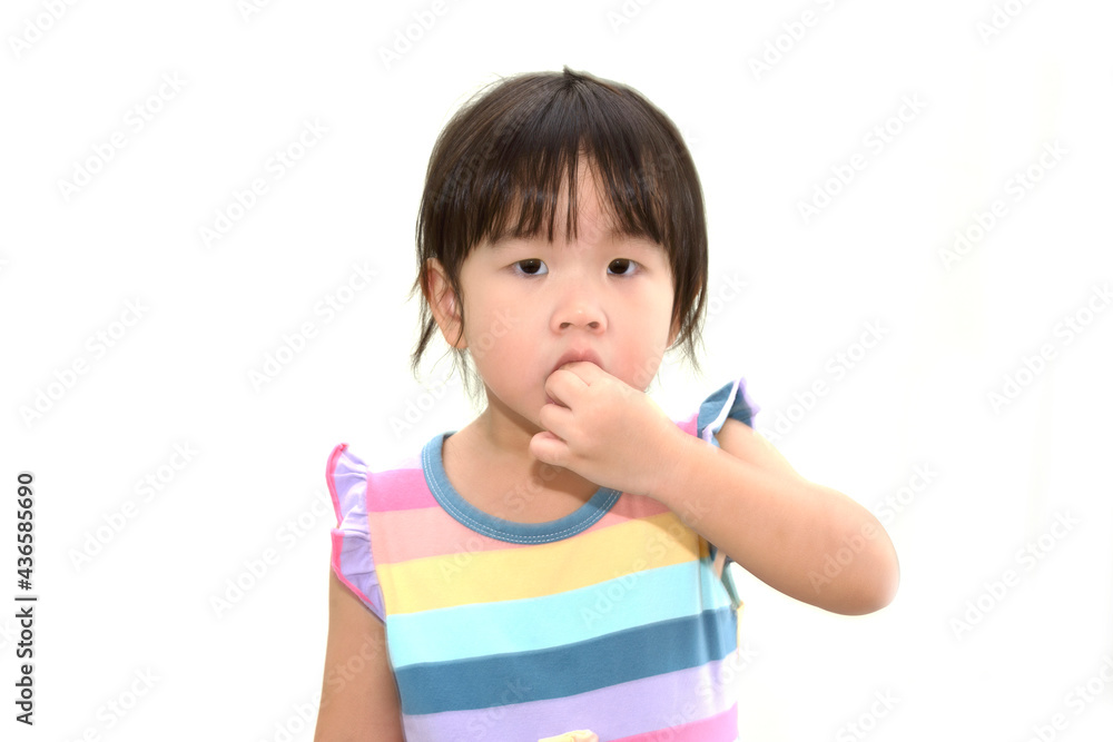 Little Asian girl using her hand to take the candy into her mouth Little Asian girl using her hand to take the candy into her mouth