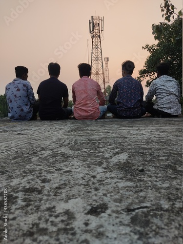 Group of happy friends stands with sun rice
