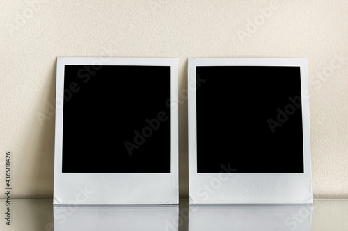 Mockup template with two polaroid photo CARDS with black squares on reflective surface.