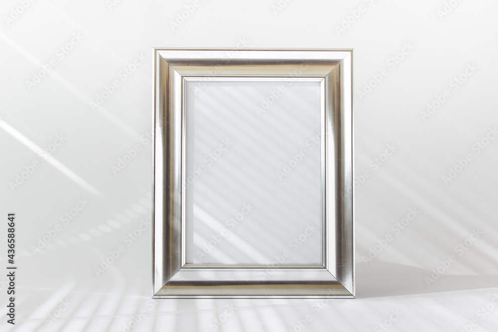 Mockup template with silver metallic wide frame with blan kspace and light rays on white background. Mockup template with silver metallic wide frame with blan kspace and light rays on white background.