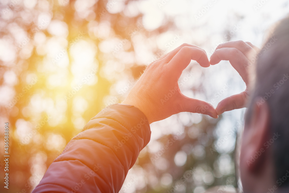 Heart with hands outdoors on sunny day at forest, closeup Heart with hands outdoors on sunny day at forest, closeup