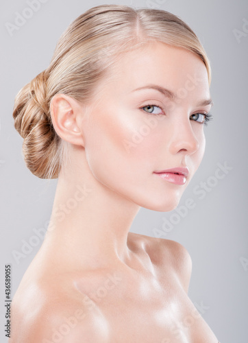 Beautiful face of young adult woman with clean fresh skin. Looking at Camera.