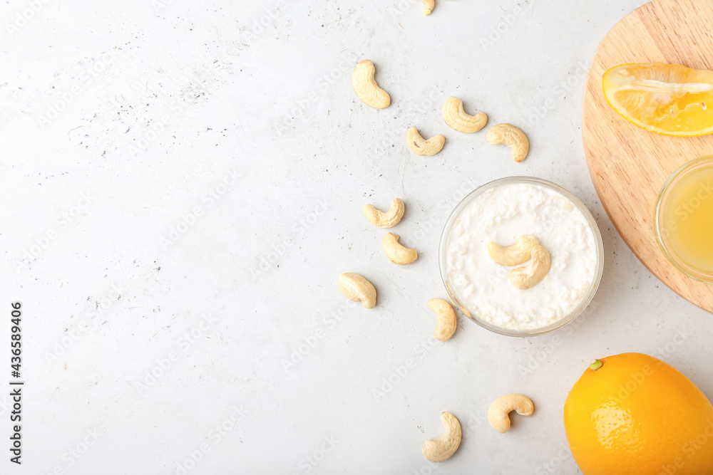 Bowl with cashew sour cream, nuts and lemon juice on light background Bowl with cashew sour cream, nuts and lemon juice on light background