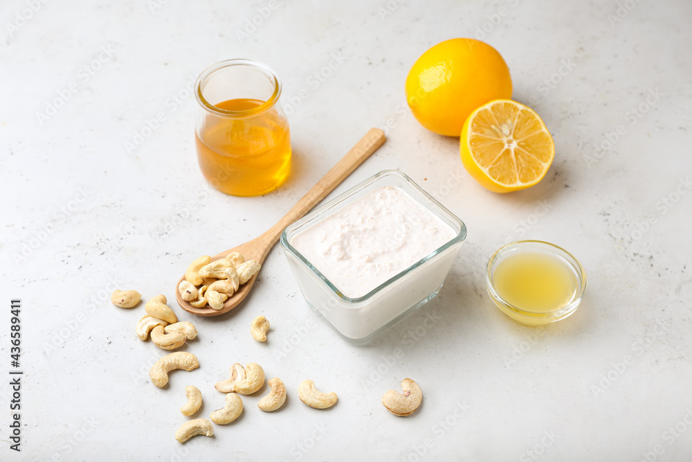 Bowl with cashew sour cream, nuts, honey and lemon juice on light background Bowl with cashew sour cream, nuts, honey and lemon juice on light background