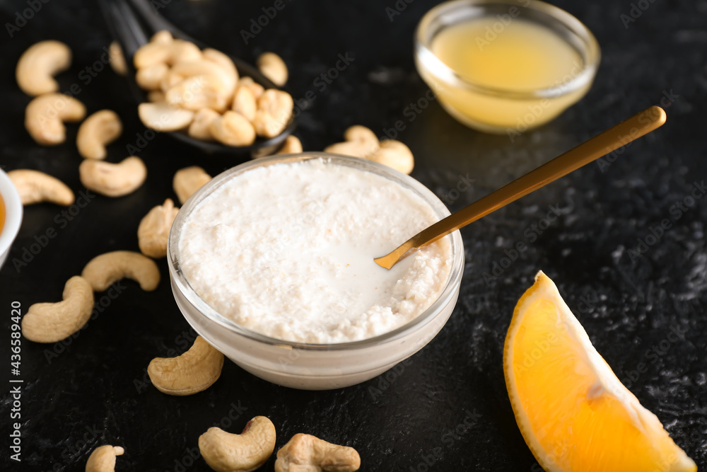 Bowl with cashew sour cream, nuts and lemon juice on dark background, closeup Bowl with cashew sour cream, nuts and lemon juice on dark background, closeup