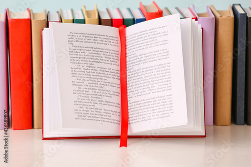 Open book with red ribbon b...