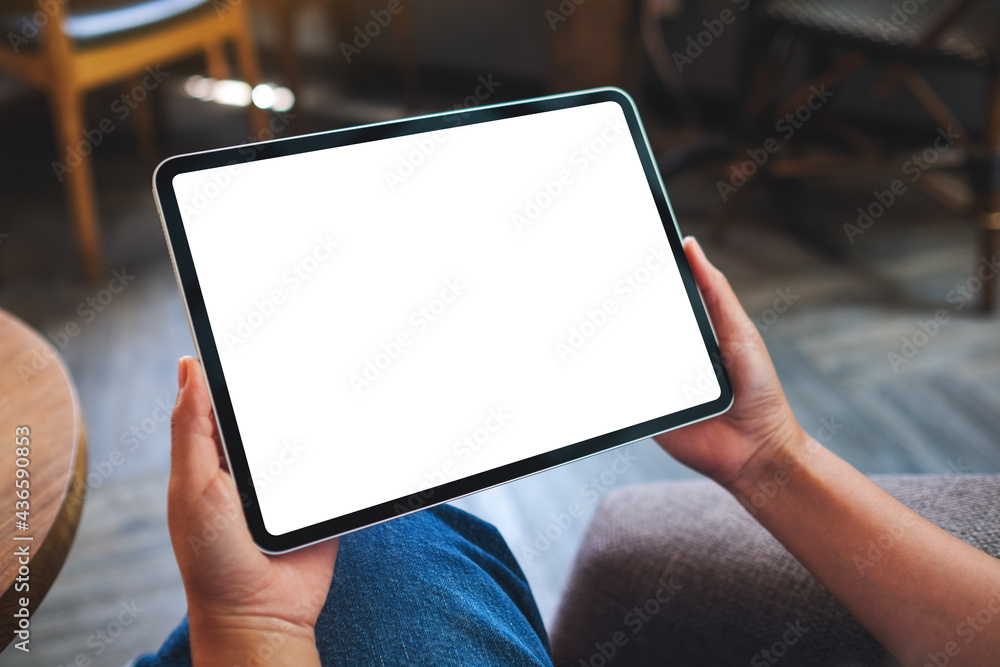 Mockup image of a woman holding digital tablet with blank white desktop screen