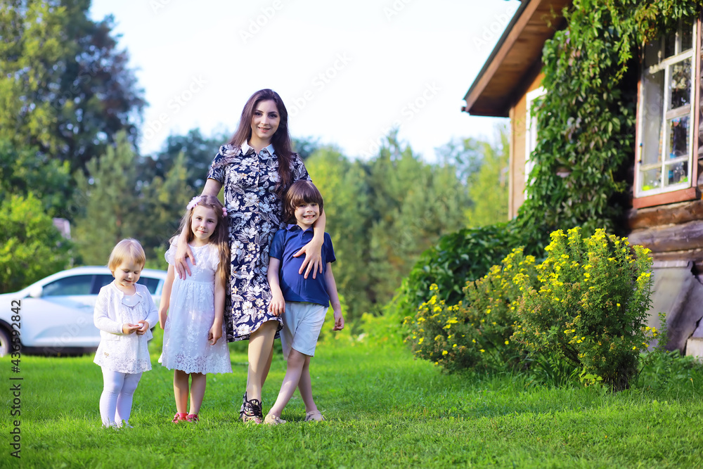 Young large family on a summer morning walk. Beautiful mother with children is playing in the park. Young large family on a summer morning walk. Beautiful mother with children is playing in the park.