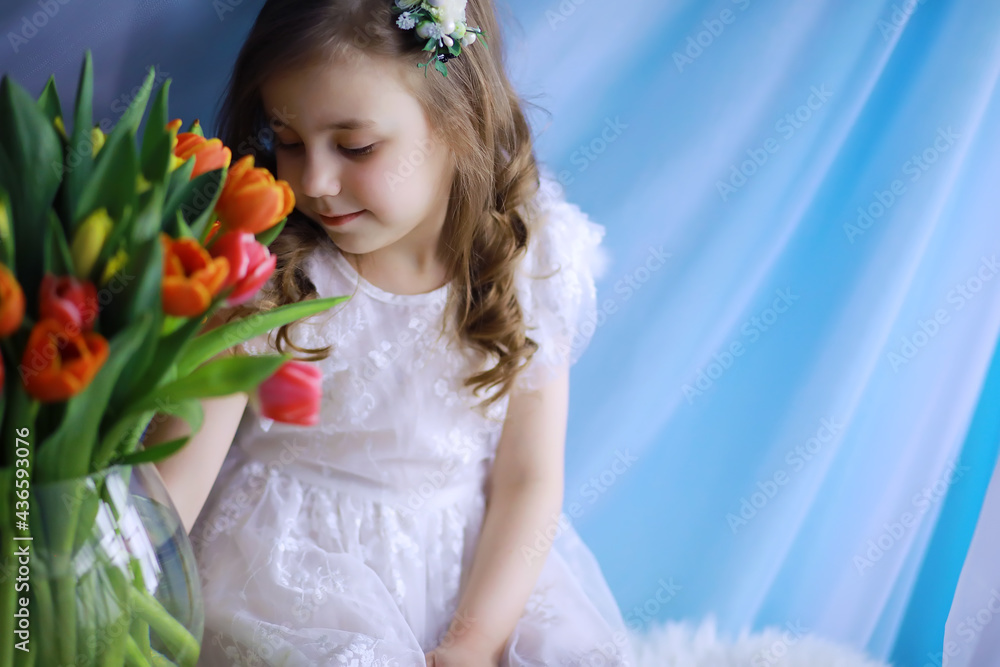 Beautiful girl in white dresses with a magnificent bouquet of the first tulips. International Women's Day. Girl with tulips. Beautiful girl in white dresses with a magnificent bouquet of the first tulips. International Women's Day. Girl with tulips.