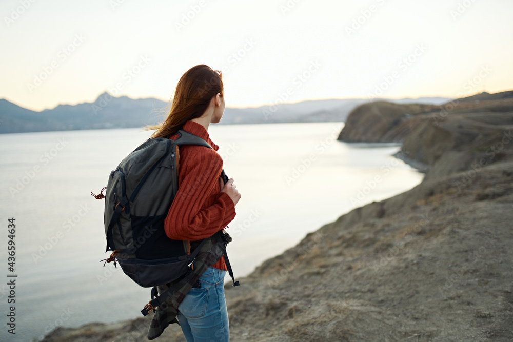 travel tourism young woman with backpack by the sea in the mountains nature