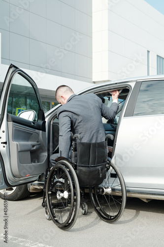 Disabled businessman in wheelchair getting into his car after work © pressmaster