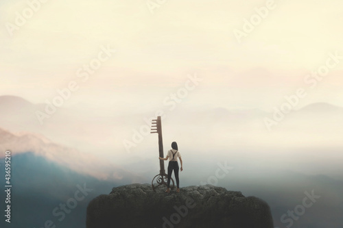 woman on top of a mountain carries a big surreal key, solution concept