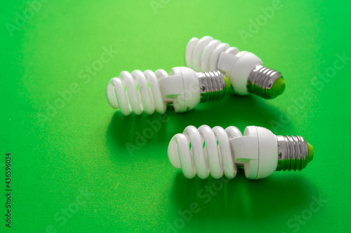 Light bulb on green paper background close up
