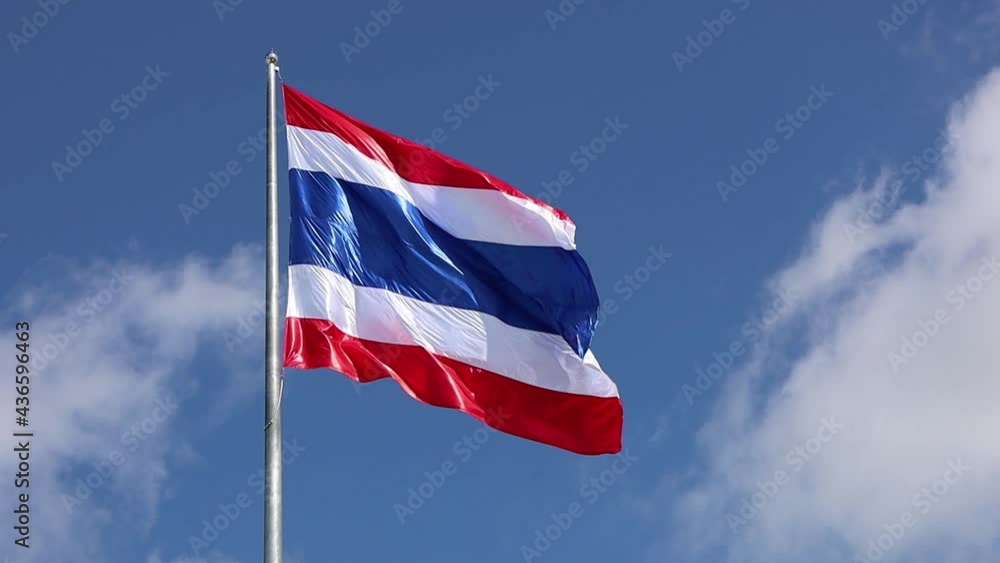 The Thai flag waved slowly in the wind. The symbol of Thai fluttering beautifully on a blue sky background. The Thai flag waved slowly in the wind. The symbol of Thai fluttering beautifully on a blue sky background.