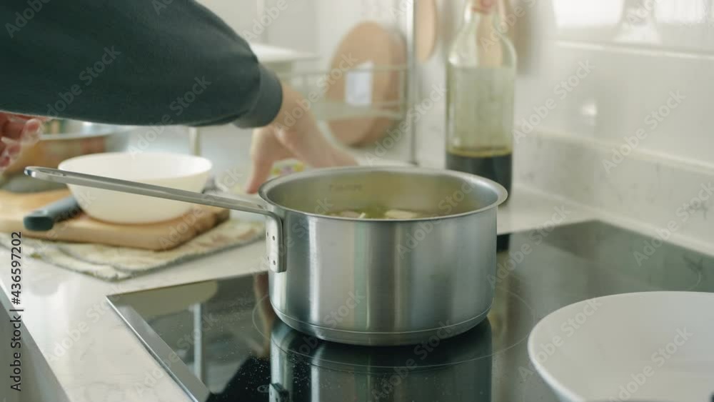 Woman cooking soup on kitchen. Close up of housewife stirring soup with spoon at stove on domestic kitchen. Woman cooking soup on kitchen. Close up of housewife stirring soup with spoon at stove on domestic kitchen.