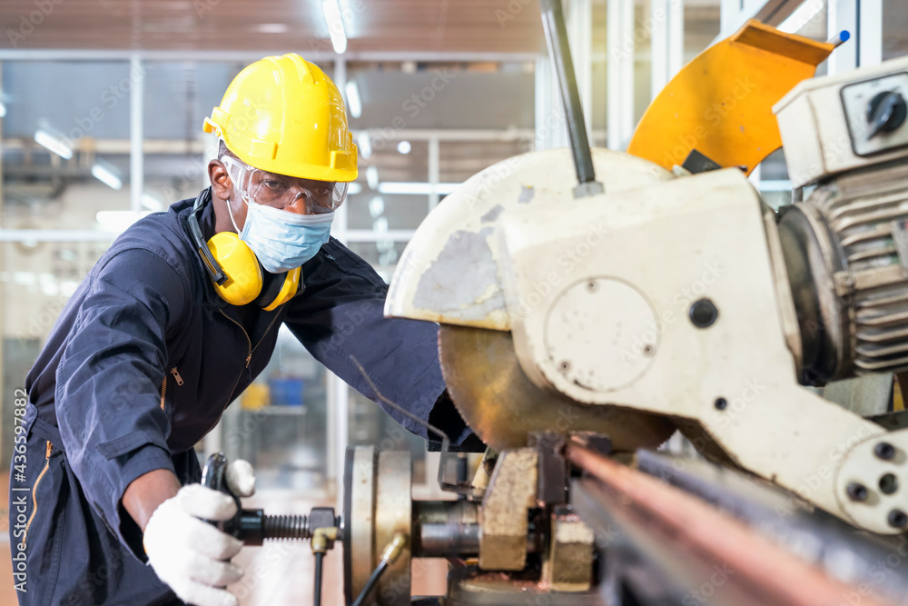 A factory mechanic is using a chainsaw to cut copper pipes. An expert technician is inspecting industrial machinery in a steel manufactory. A factory mechanic is using a chainsaw to cut copper pipes. An expert technician is inspecting industrial machinery in a steel manufactory.