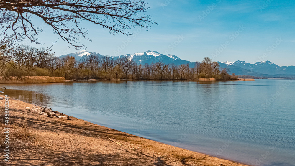 Beautiful alpine spring morning view with reflections and the alps in the background at the famous Chiemsee, Chieming, Chiemgau, Bavaria, Germany