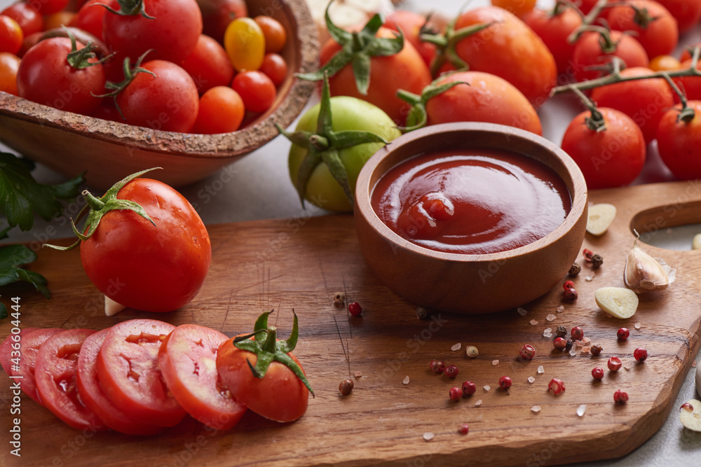 tomato sauce with garlic and vibrant green leaves of the italian parsley plant. tomato ketchup sauce in a bowl with spices, herbs and cherry tomatoes. top view. tomato sauce with garlic and vibrant green leaves of the italian parsley plant. tomato ketchup sauce in a bowl with spices, herbs and cherry tomatoes. top view.