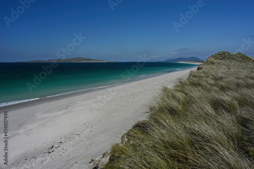 West Beach  Berneray  Outer Hebrides  Scotland. Sunny day with blue sky  white sand  turquoise and blue water. Taken from high point on dunes showing dune grass. Mountains in distance. No people.