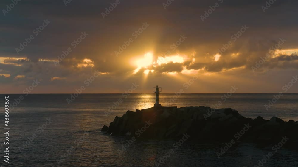 Sunset at a beach with a small lighthouse in Madeira, Portugal Sunset at a beach with a small lighthouse in Madeira, Portugal