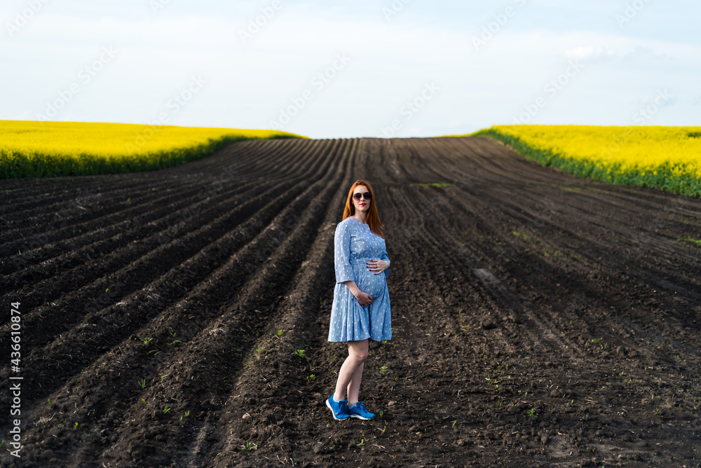 Pregnant woman on the summer field