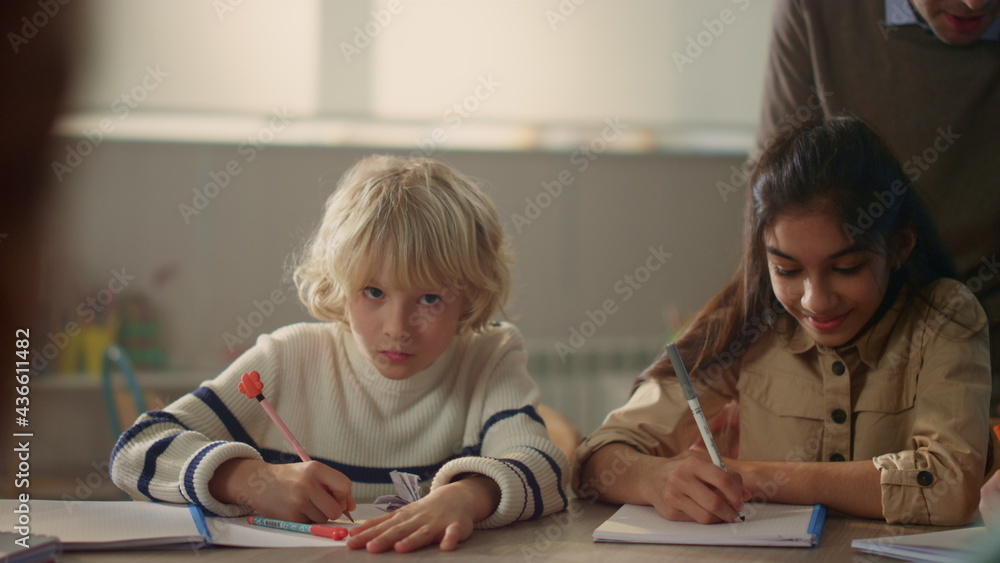 Schoolchildren writing in notebooks. Students making notes in exercise books Schoolchildren writing in notebooks. Students making notes in exercise books