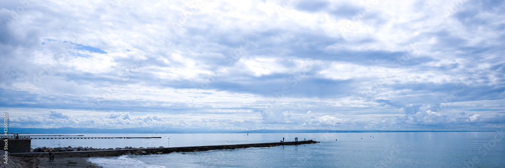 pier with fishermen, in the background the sea and a cloudy sky. banner