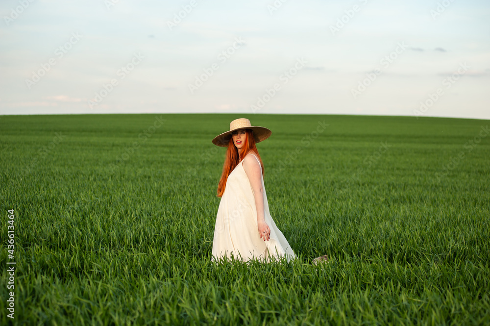 Pregnant woman on the summer green field wearing long white dress Pregnant woman on the summer green field wearing long white dress